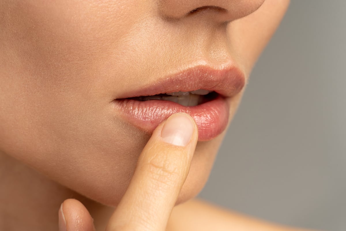 Woman Applying Moisturizing Nourishing Lip Balm
